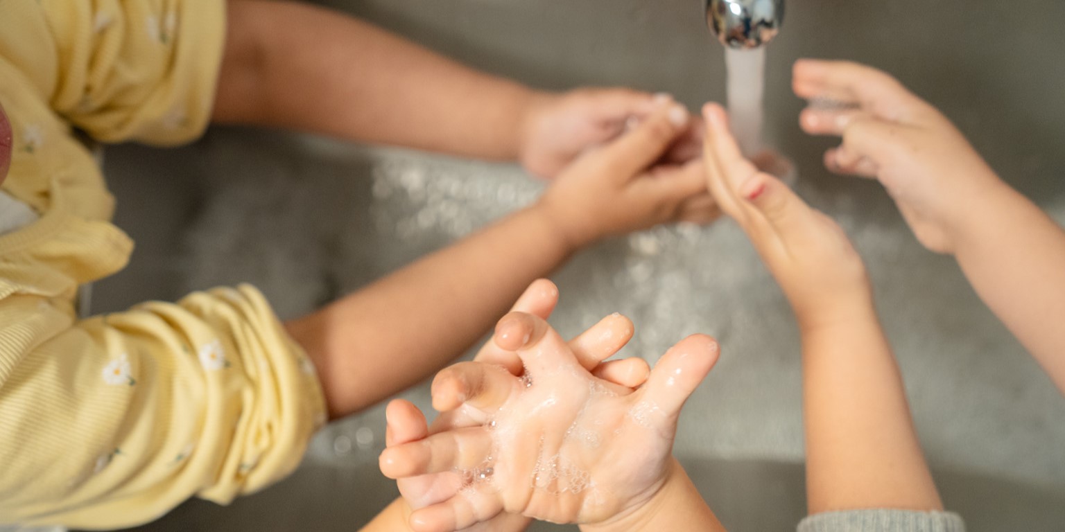 kinderen wassen hun handen onder de kraan